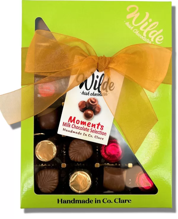 'Moments' Large Milk Choc Assortment displayed in its green packaging with a golden bow.