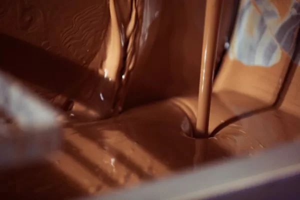 A stream of melted chocolate being poured.