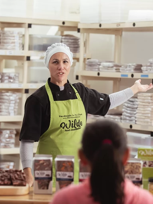 A Wilde Irish Chocolate staff member speaks to children at a factory tour.