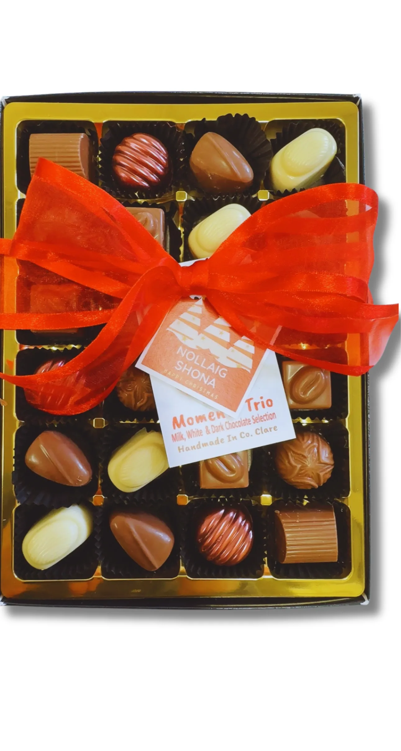 Box of milk, white and dark chocolates tied with a red ribbon and a Nollaig Shona (Happy Christmas ) Tag